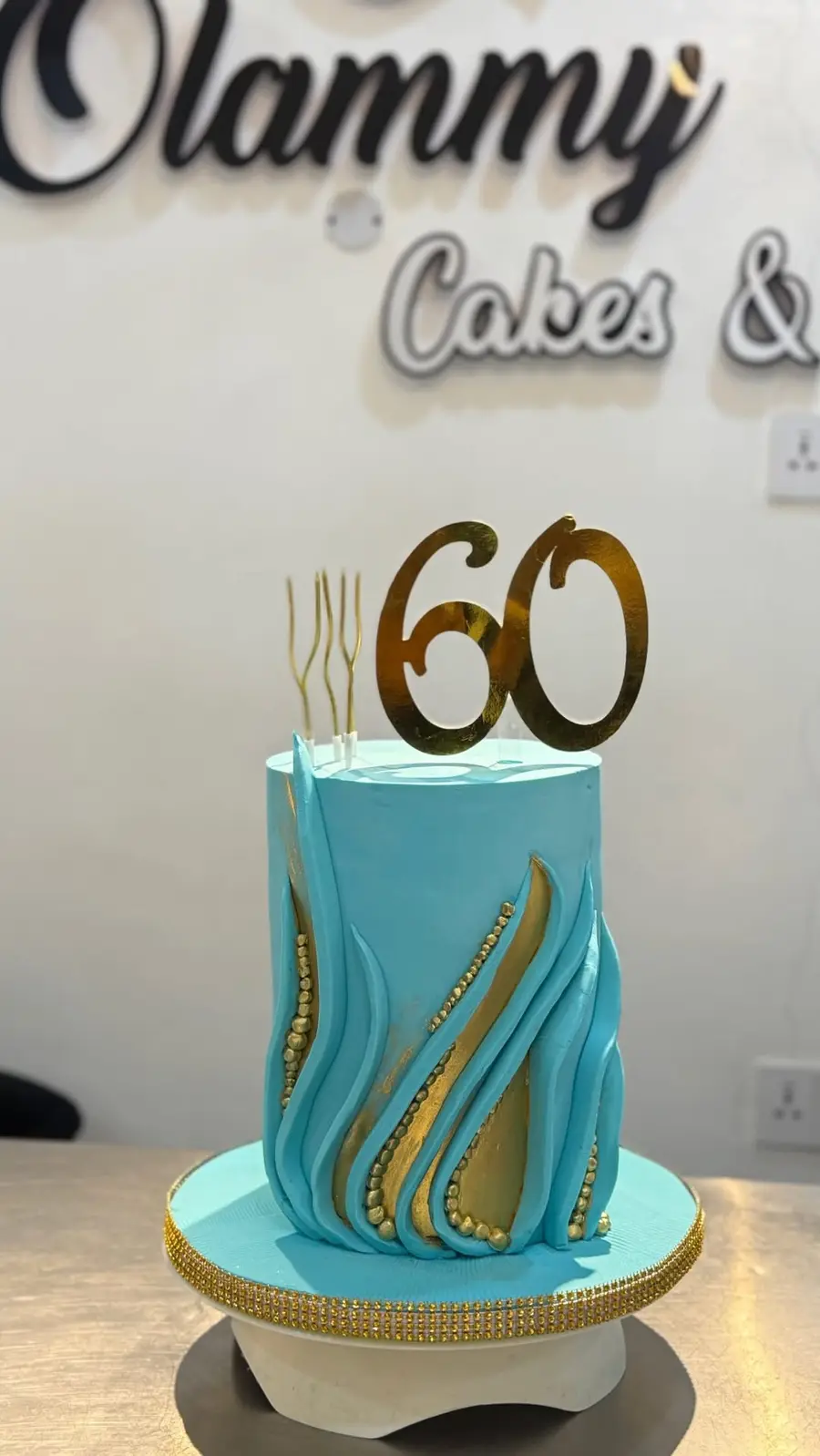Blue 60th birthday cake in the Olammy Cakes studio