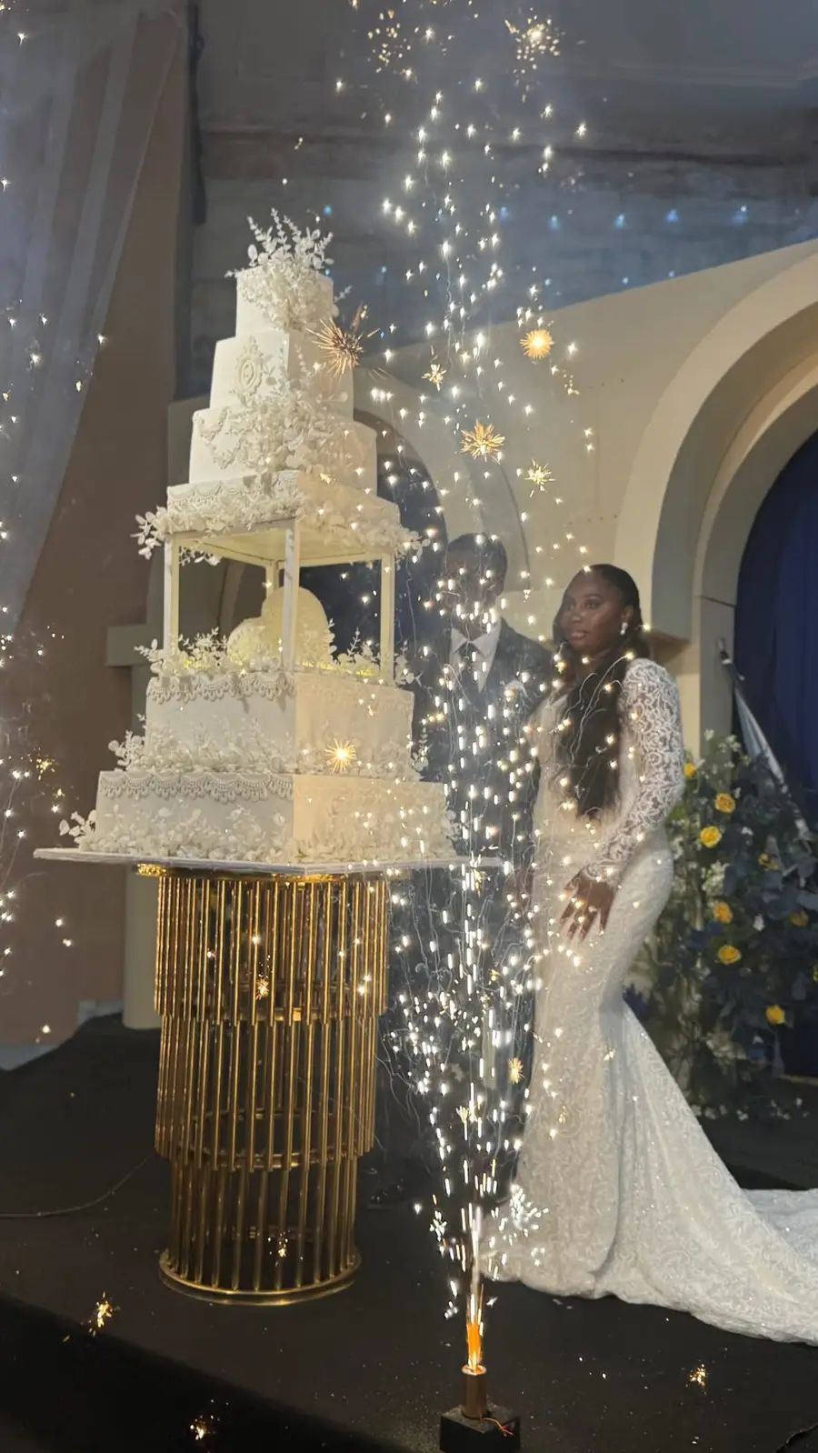 Tall white wedding reception cake with sparklers at an Akure wedding